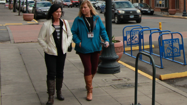 Pedestrians walking down sidewalk on city main street