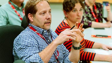 Man and women engaging in conversation at meeting