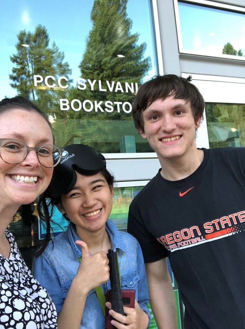 Group of three people in front of a college bookstore.