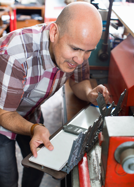 Man sets up material for die cutting.