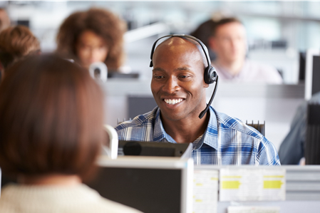 Blind man wearing a headset works in an office.
