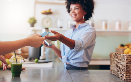 Blind woman behind a counter conducts a credit card transaction.