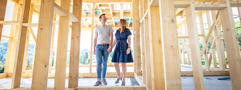 Man and woman walking through framed house