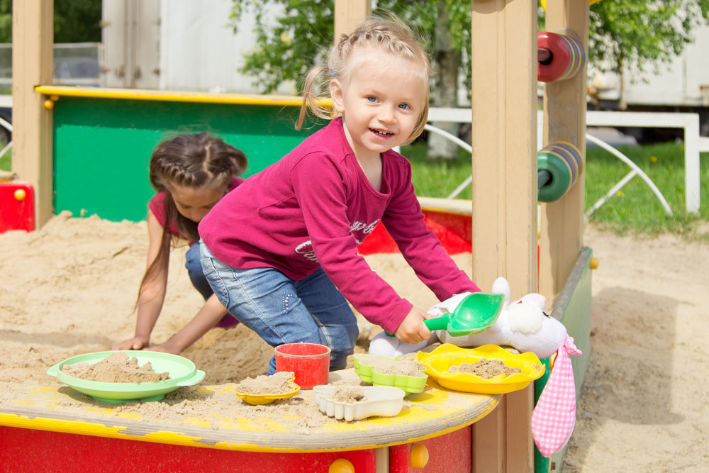 child playing in sandbox