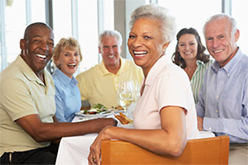 Image of adults smiling around a table