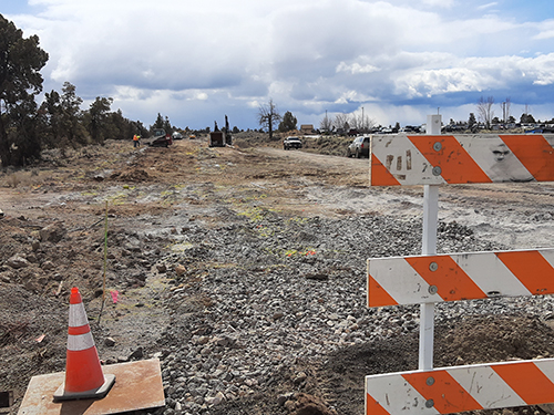 Caution cone and sign on dirt lot