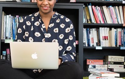 Decorative image of a smiling woman working on a laptop.