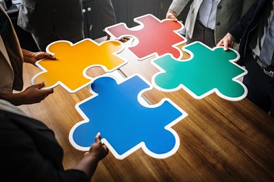 Decorative image of people putting puzzle pieces together.