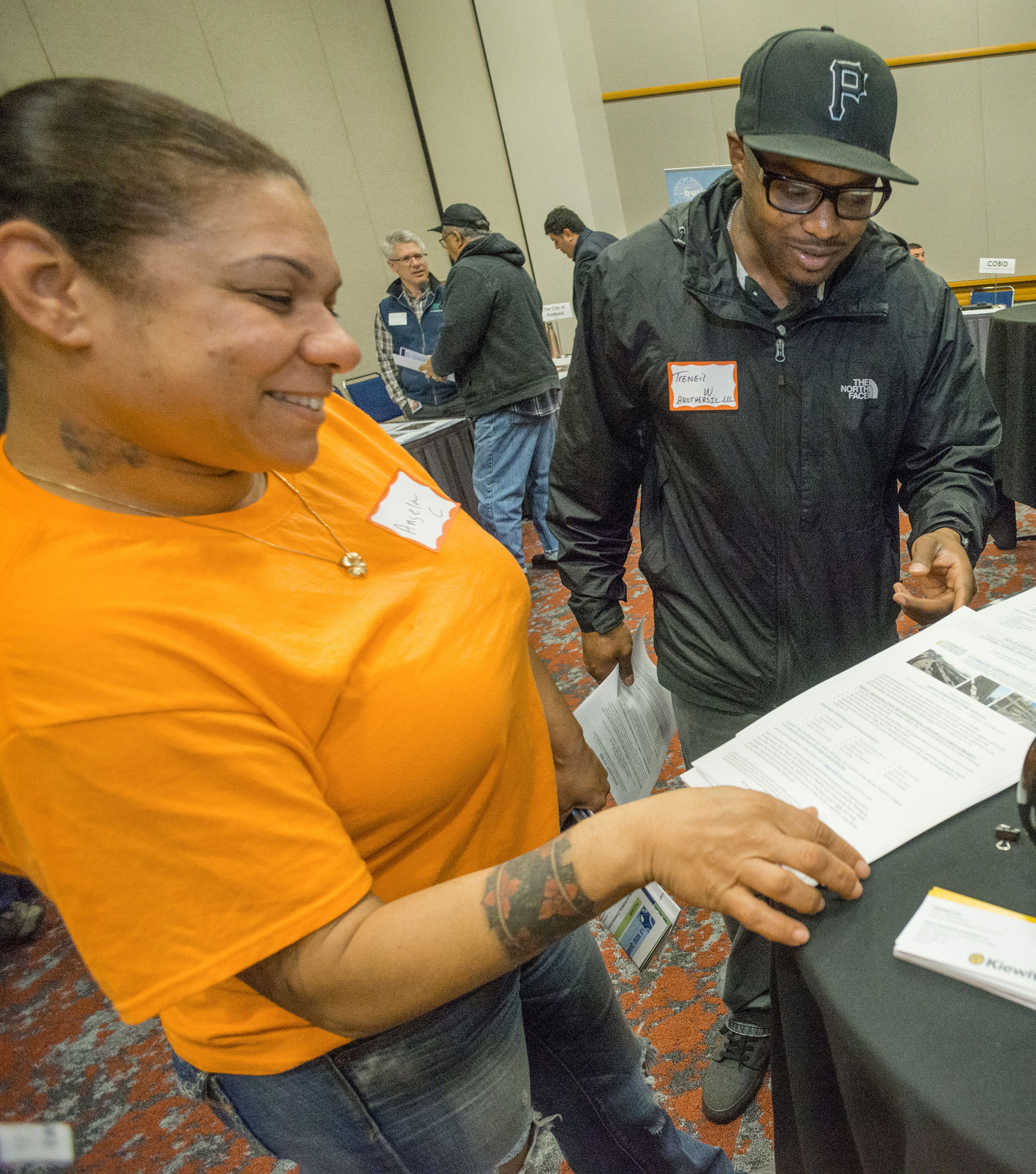 Two people at an event table viewing information about small business programs.