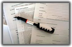 paper contracts slightly spread out on a desk with a pen lying on top of them