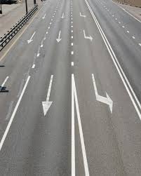 Cinco carriles en una autopista que indican múltiples direcciones: una salida recta, otra salida recta, un carril central para g