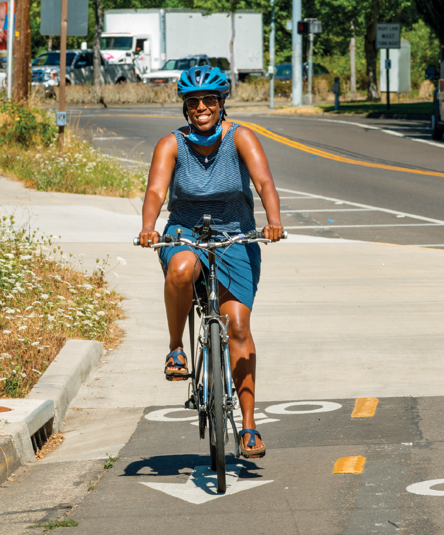 A woman riding on a bicycle down a street
