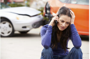 woman sitting on curb with phone