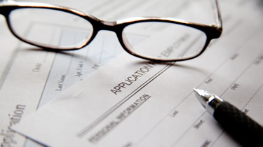 Pair of glasses resting on a stack of paper