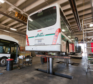Bus on a hydraulic lift in mechanic shop