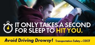 Drowsy Driving billboard with photo of a man at the wheel of a car - Text reads - It only takes a second for sleep to hit you. 