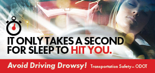 Drowsy Driving billboard with photo of a woman at the wheel of a car - Text reads - It only takes a second for sleep to hit you.