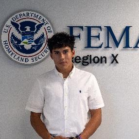 Person standing in front of a wall with a FEMA Region 10 logo