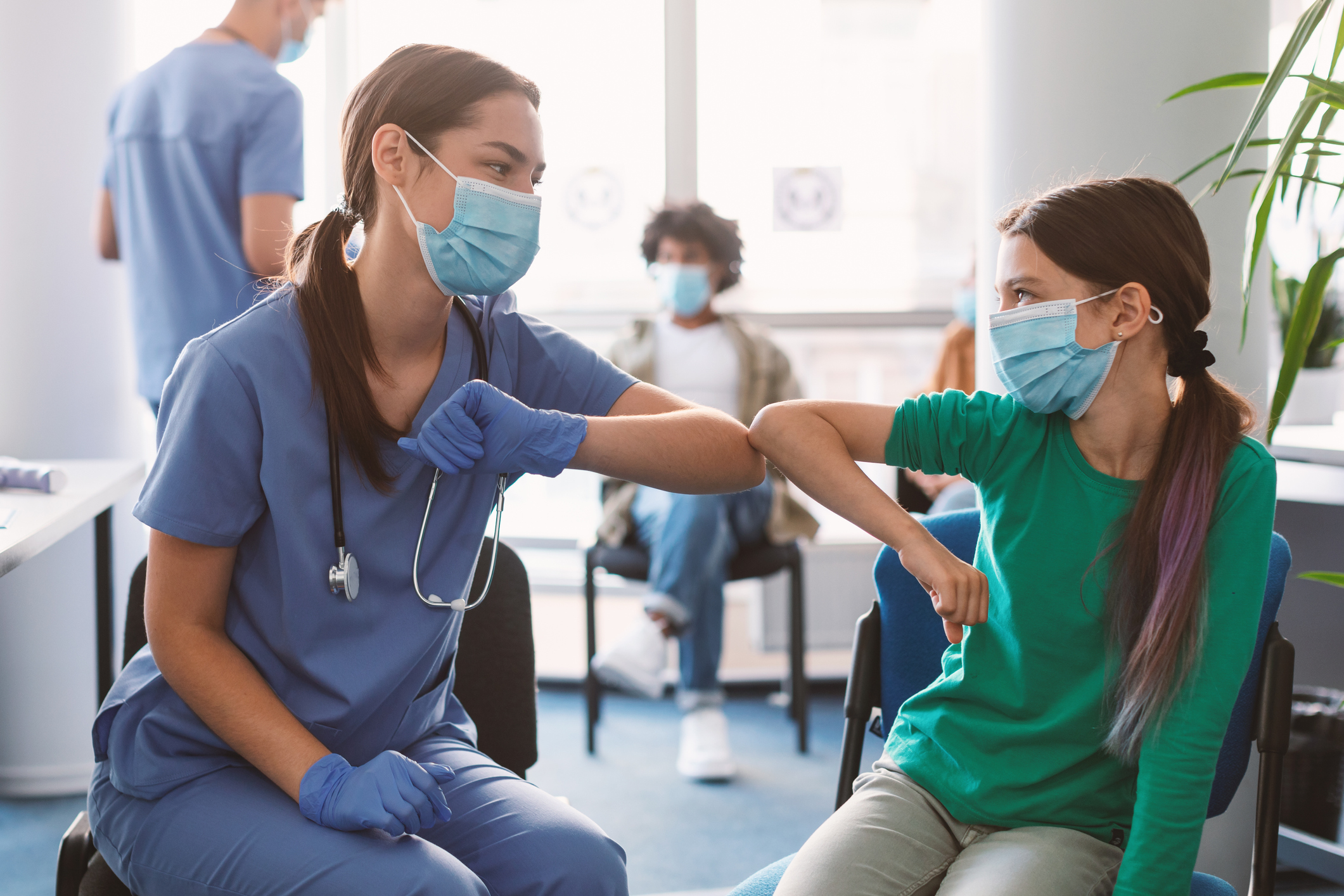 Masked Health Care Provider Elbow Bumping Masked Child