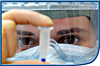 Closeup of lab worker wearing protective face gear examining a specimen