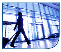 traveler pulling a wheeled suitcase through airport terminal