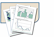 Magnifying glass being used to examine a stack of charts and graphs