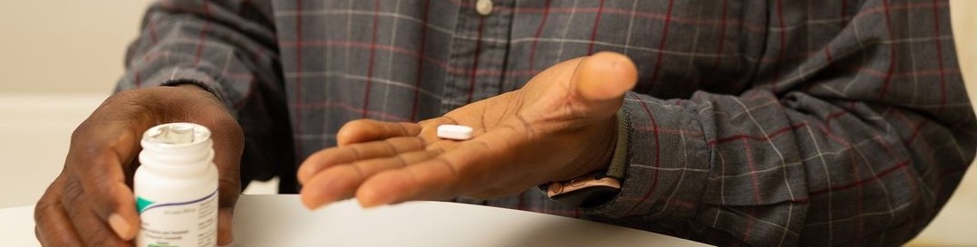 Decorative image - hands holding a pill bottle and pill