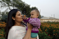 Mom holding baby outside near a tree