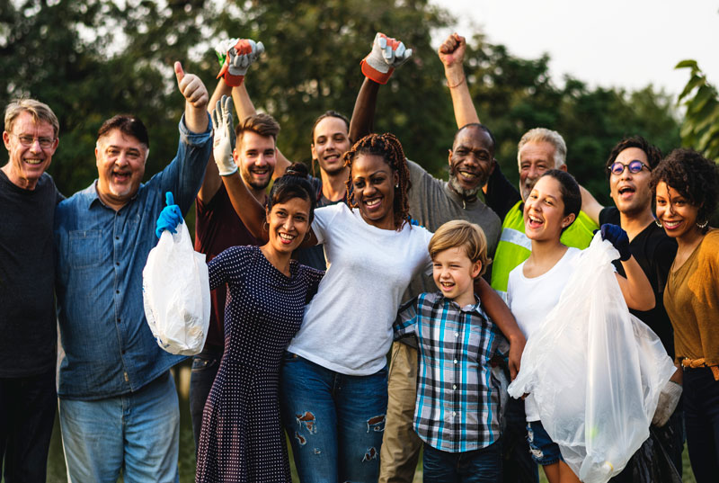 Image of a smiling divirse group of people wearing work gloves