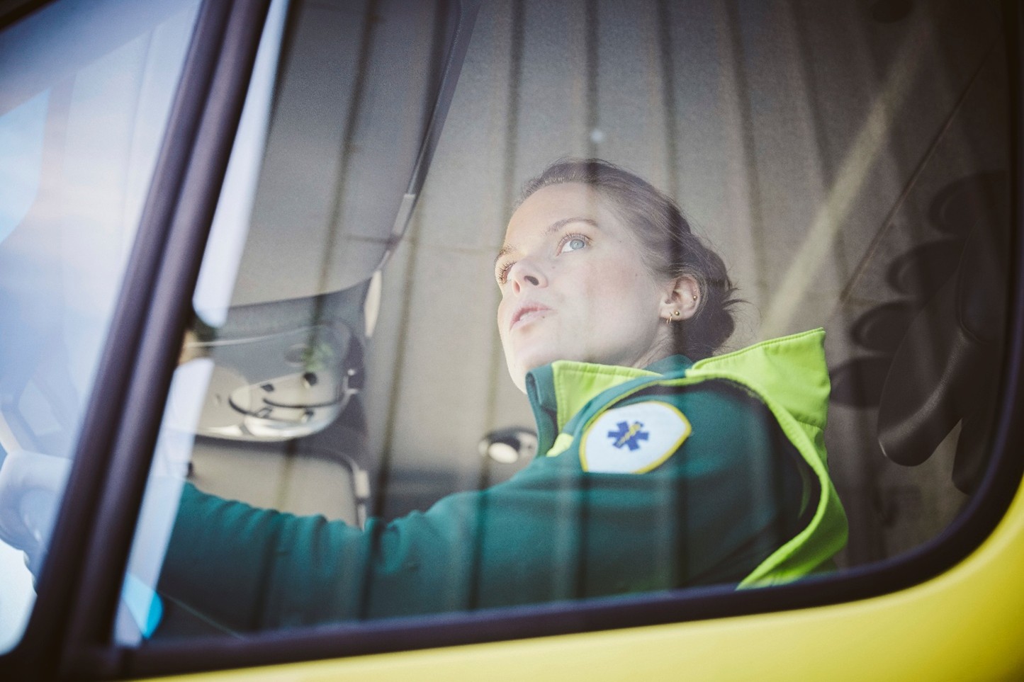 An abulance driver looks out her window.