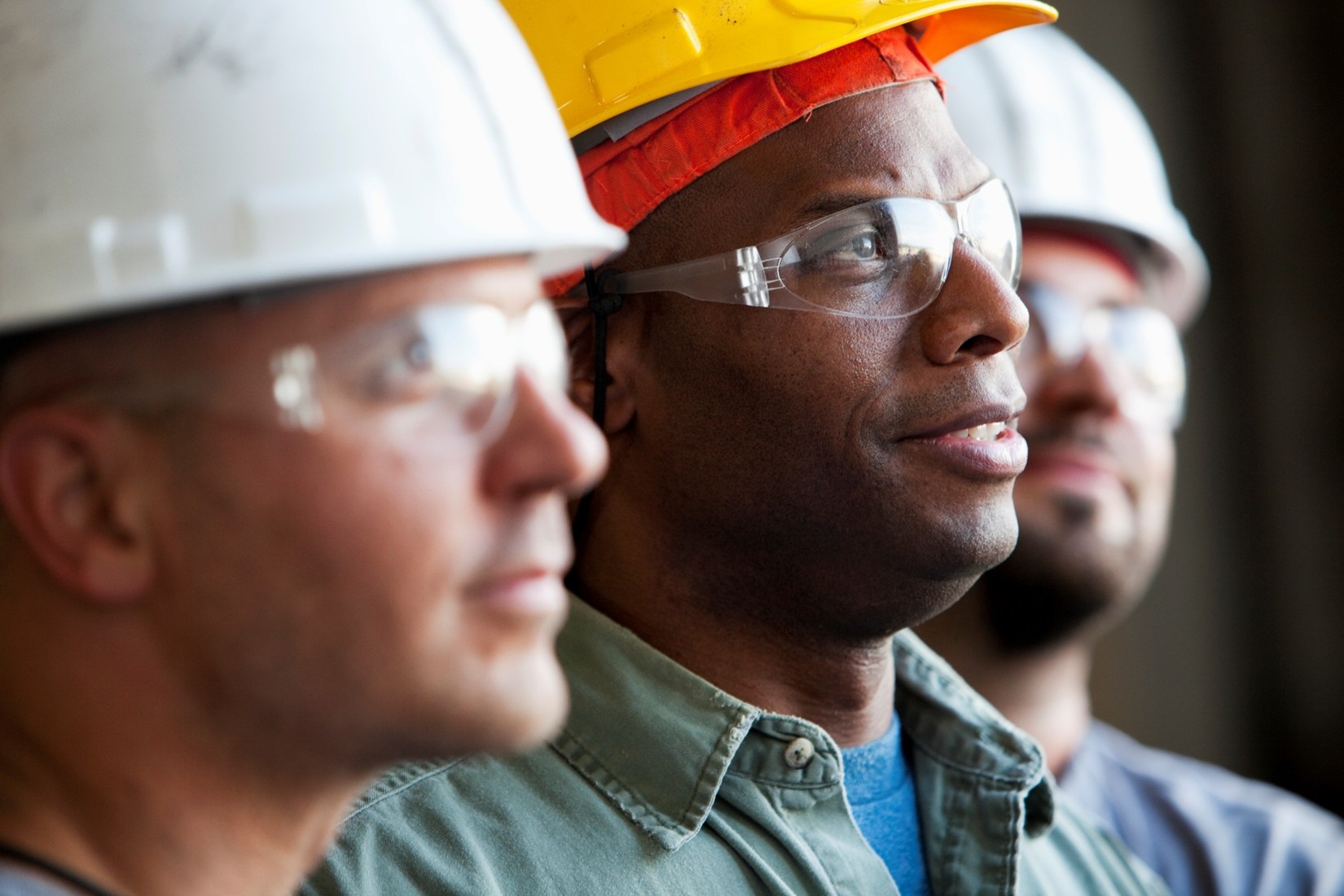 3 workers wearing hard hats and safety glasses