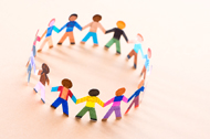 Brightly colored paper dolls holding hands in a circle