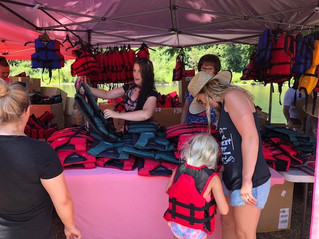 Meg's step-sister Ashley and Aunt Lonnie explaining life jacket sizes during a Meg's Moments life jacket giveaway