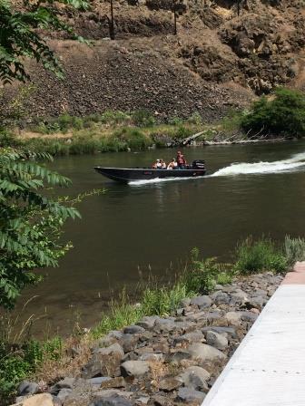 Motorboat on plane passing a boat ramp on the Deschutes River
