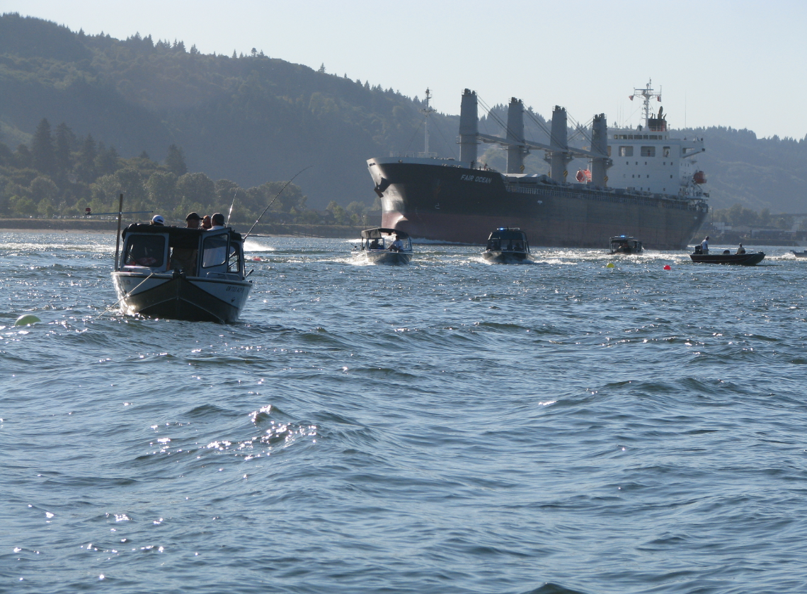 Motorboats and marine law enforcement making way of the main channel to allow a large vessel the right of way