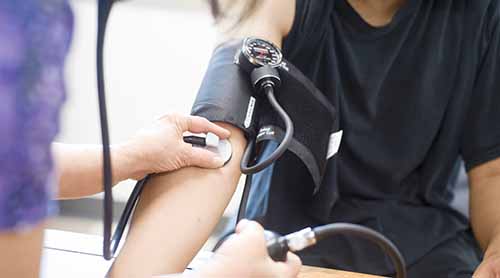 nurse taking a youth's blood pressure