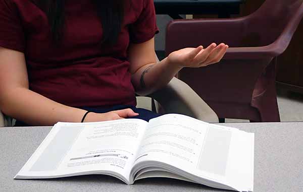 youth talking with book in front of them