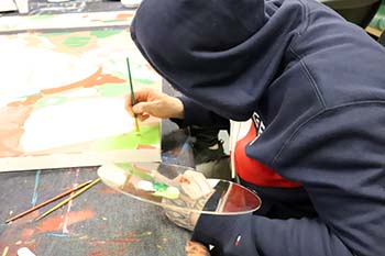 a young person painting a mural