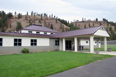 facade of camp riverbend with mountains in background.JPG
