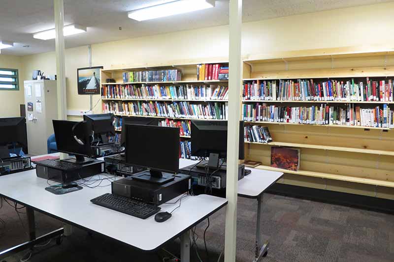computers on table and shelves of books