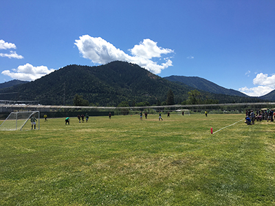 soccer game on field in front of rolling hills