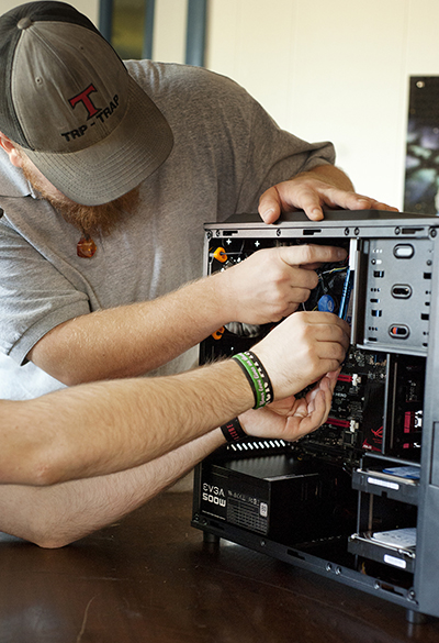 Men work with wires inside computer box