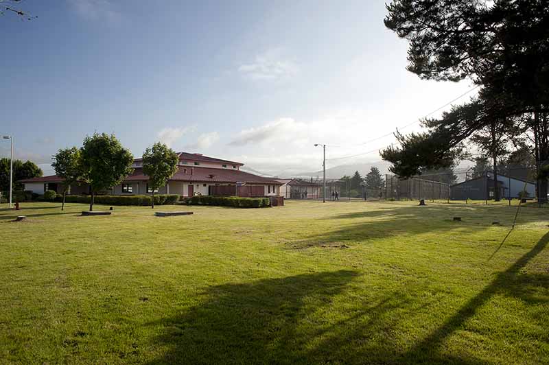 Tillamook facility facade with fence and high school.jpg
