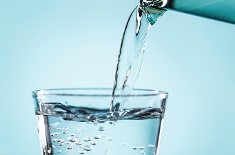 Bottle pouring water into glass