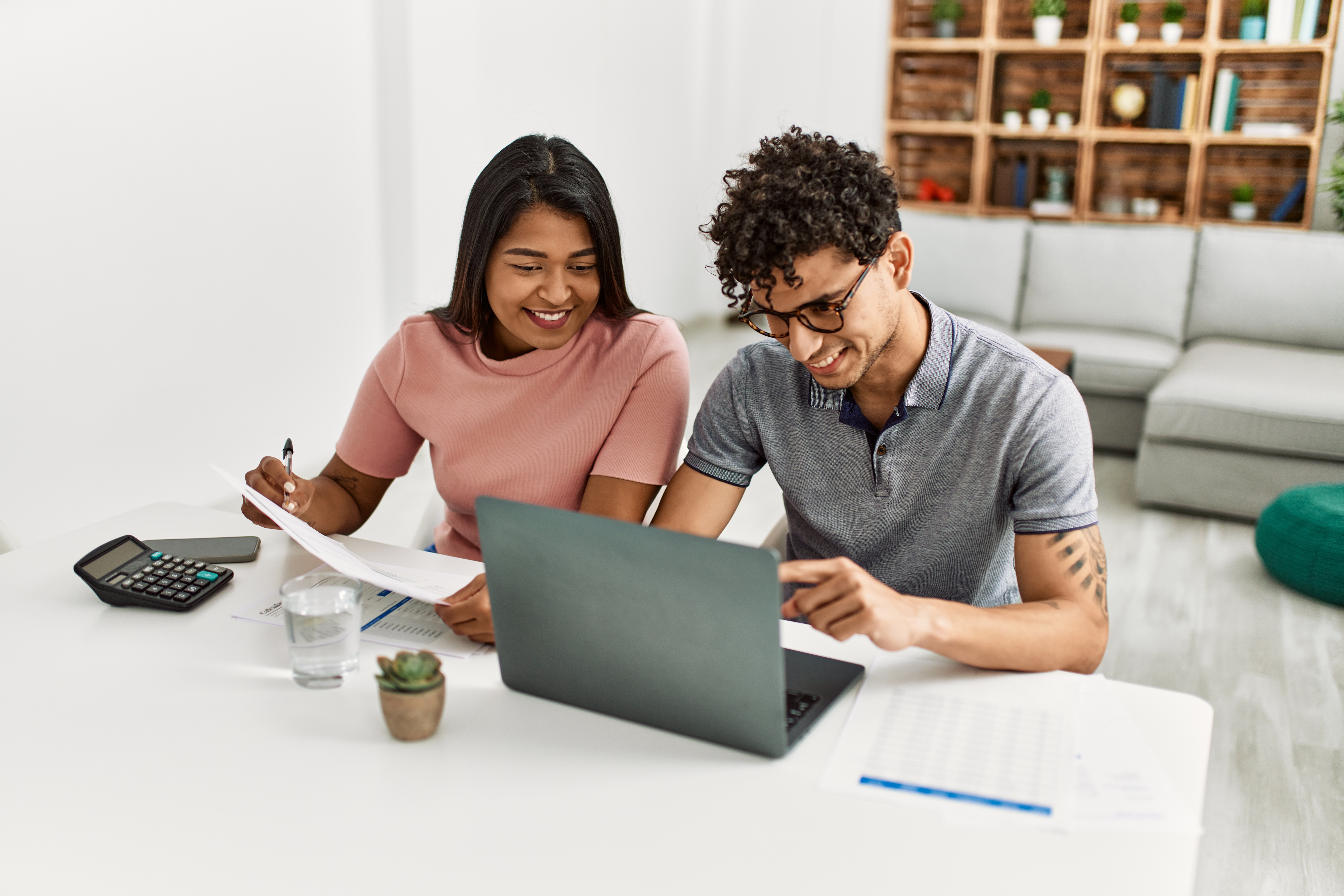 Young adults writing and using laptop