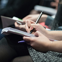 picture of a hand holding a pen at a conference