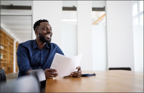 Person smiling with papers in hand