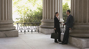 Photograph of people standing next to a column